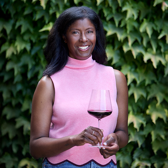 Victoria Coleman, wearing a pink top and holding a glass of red wine